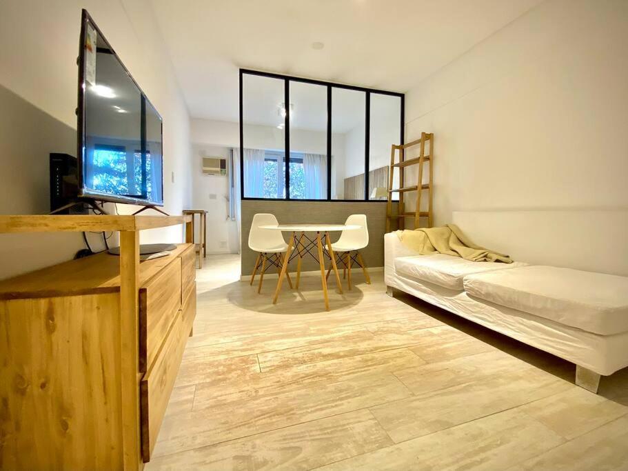 HART - Studio Patio Bullrich في بوينس آيرس: غرفة معيشة مع سرير وطاولة مع كراسي