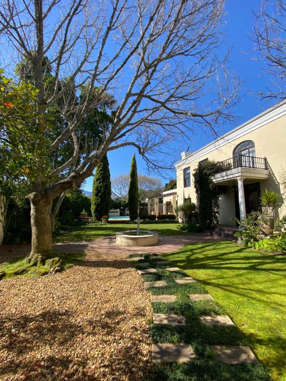 une maison avec un arbre et une passerelle dans l'établissement @Leisure Guest Suite, à Stellenbosch