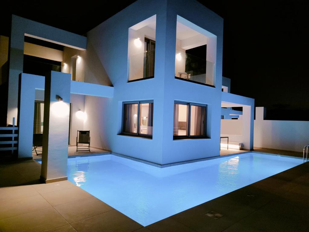 a house with a swimming pool at night at Alpha Villas in Gennadi