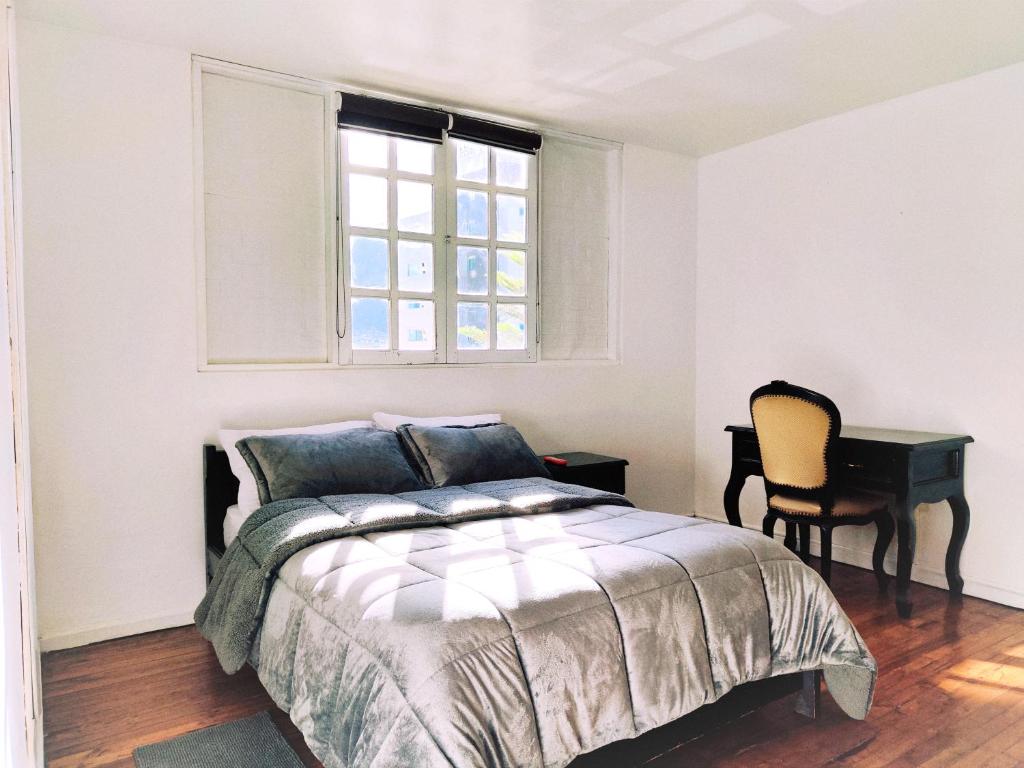 - une chambre avec un lit, une fenêtre et un bureau dans l'établissement Hotel Muros Quito, à Quito