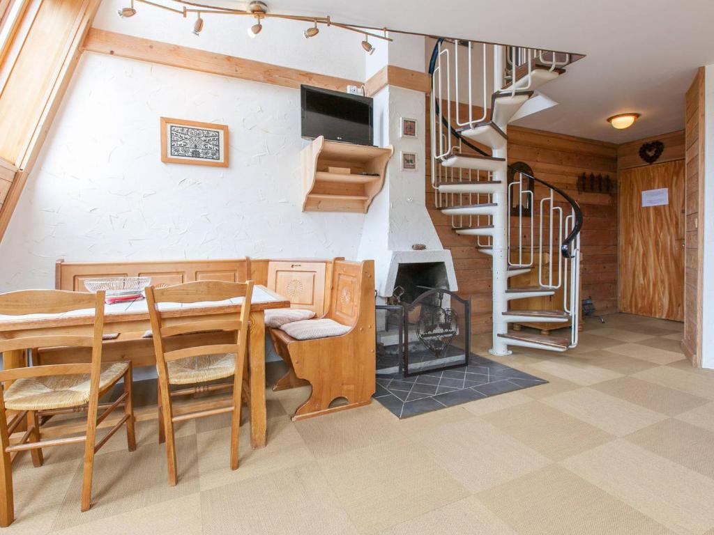 une salle à manger avec une table et un escalier en colimaçon dans l'établissement Charmant duplex pour 6 personnes avec cheminée et balcon exposé sud à Avoriaz - FR-1-314-199, à Morzine