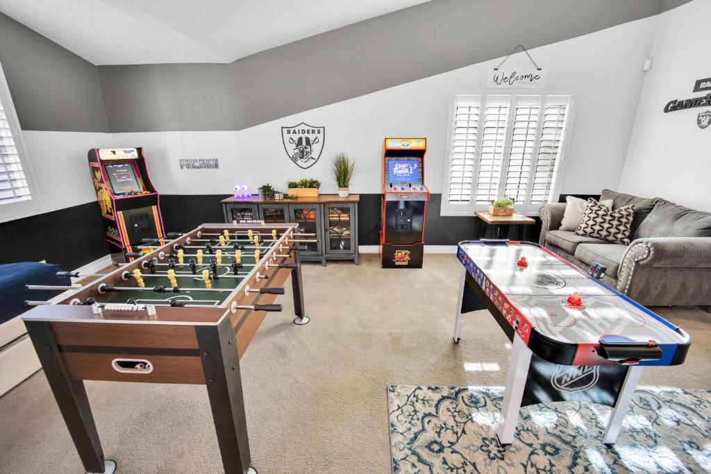 a living room with a foosball table and arcade games at Sports Themed--Automated King Bed--Family Friendly--5 miles to Strip in Las Vegas