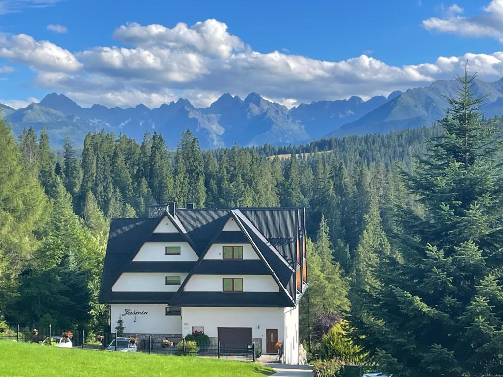 a house on a hill with mountains in the background at Jaśmin in Bukowina Tatrzańska