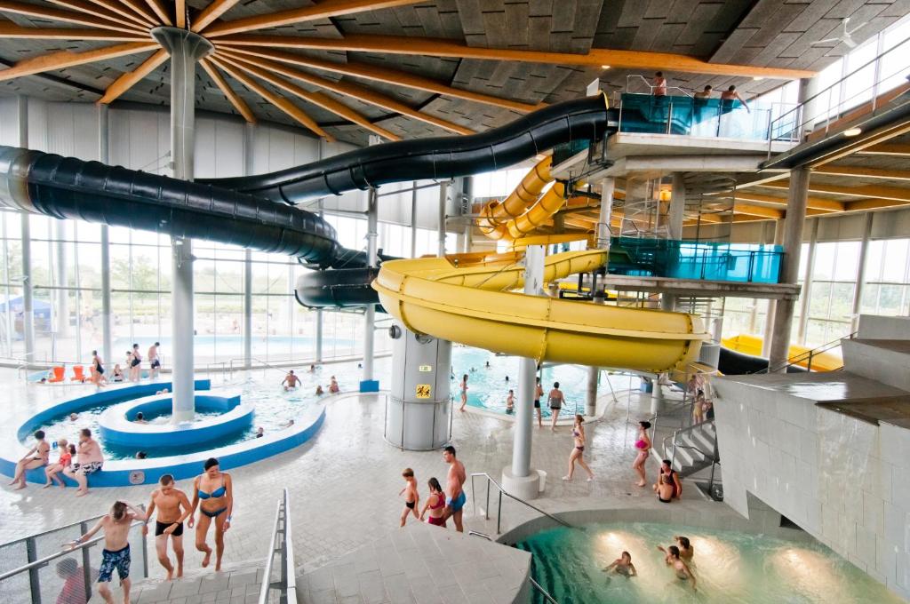 una grande piscina coperta con persone in acqua di Spa Tervise Paradiis a Pärnu