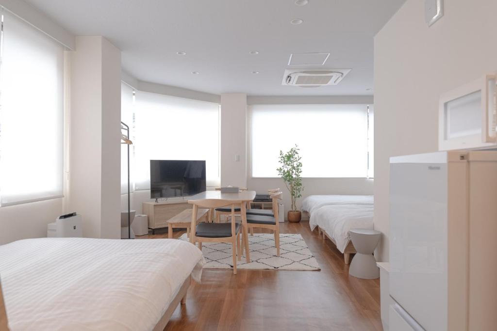 um quarto com 2 camas, uma mesa e uma televisão em RIVER VILLAS HIROSHIMA - Vacation STAY 24194v em Hiroshima