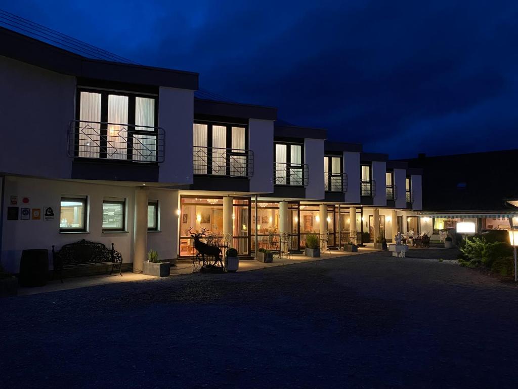 un bâtiment la nuit avec des lumières devant lui dans l'établissement Hotel Altitude, à Burg-Reuland