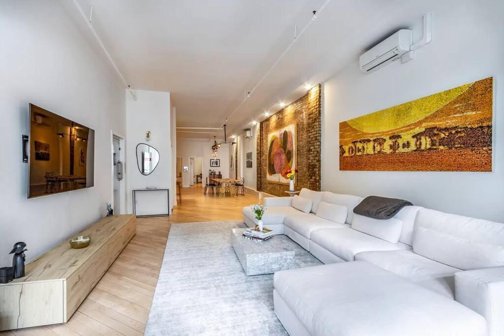 a living room with a white couch and a table at Luxurious 2 Bedroom Loft Entire Apartment in New York