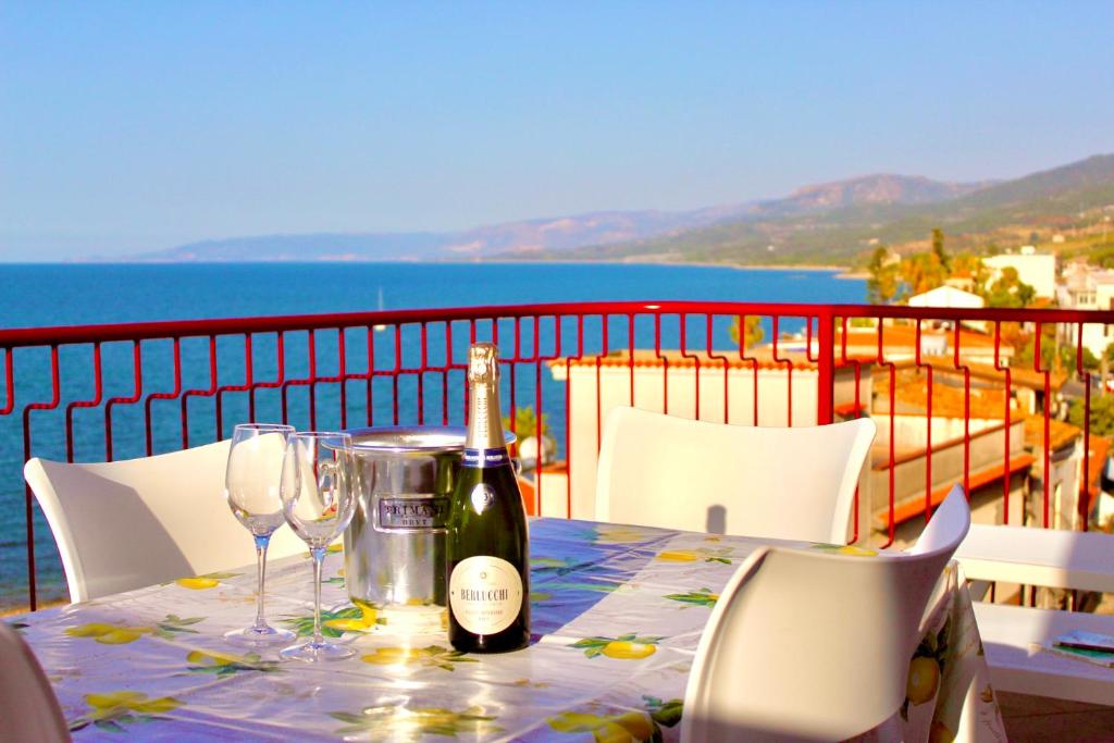 uma mesa com uma garrafa de vinho e copos em Le Terrazze sulle Eolie em Caronia Marina