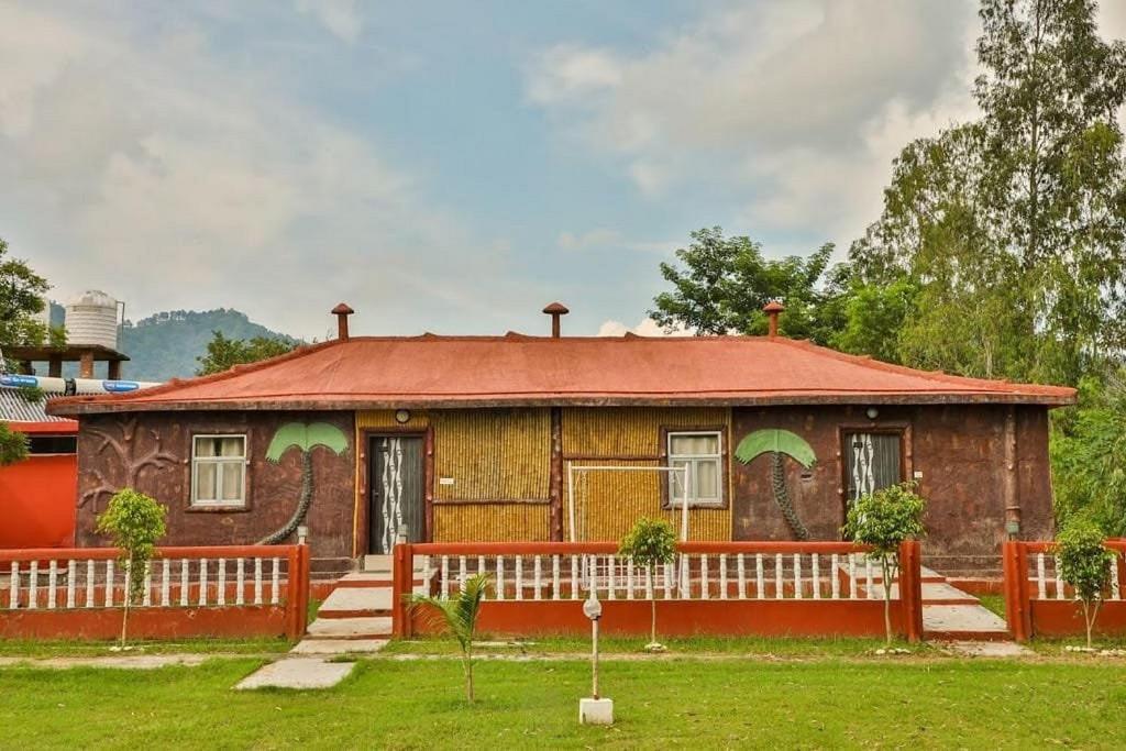 a house with a red fence in front of it at Wildlife Resort Jim Corbett in Kālāgarh