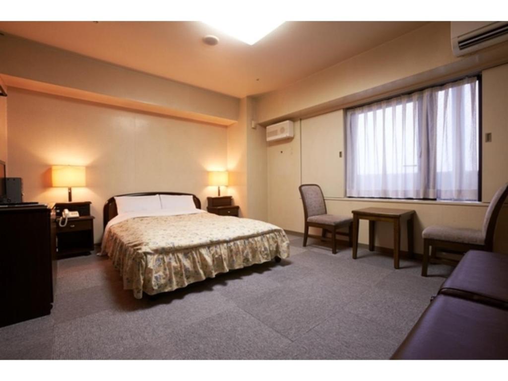 a bedroom with a bed and a table and a window at Hotel Alpha Inn Akita - Vacation STAY 67295v in Akita