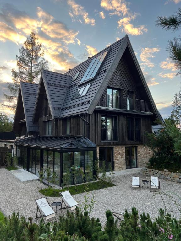 ein Haus mit einem Metalldach und Fenstern in der Unterkunft Slow Tatry Boutique Resort in Zakopane