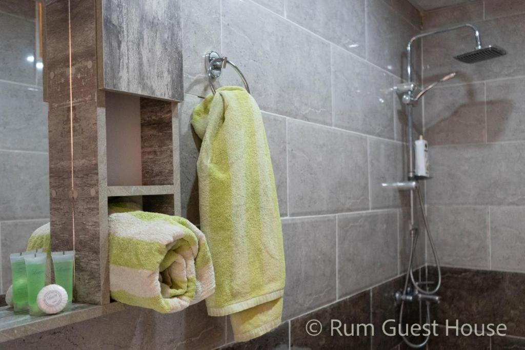 a bathroom with a shower and towels on a wall at wadi rum guest house camp in Aqaba