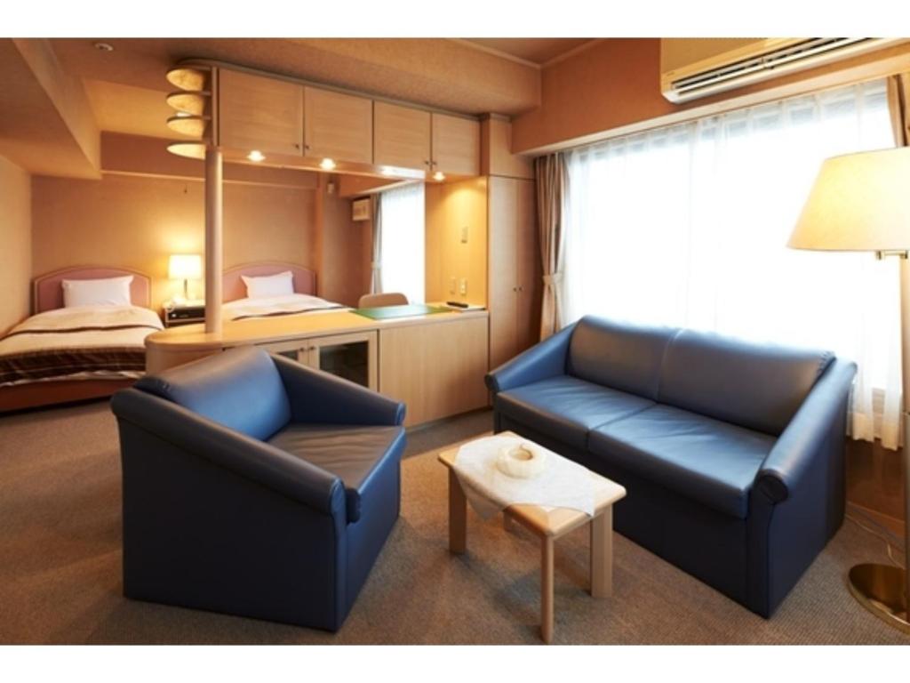 秋田市にあるHotel Alpha Inn Akita - Vacation STAY 67288vのリビングルーム(椅子2脚、ベッド1台付)