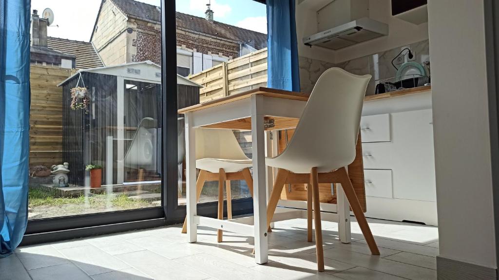 uma pequena cozinha com uma mesa e duas cadeiras em Maisonnette entière et privée, 600m de la gare em Margny-lès-Compiègne