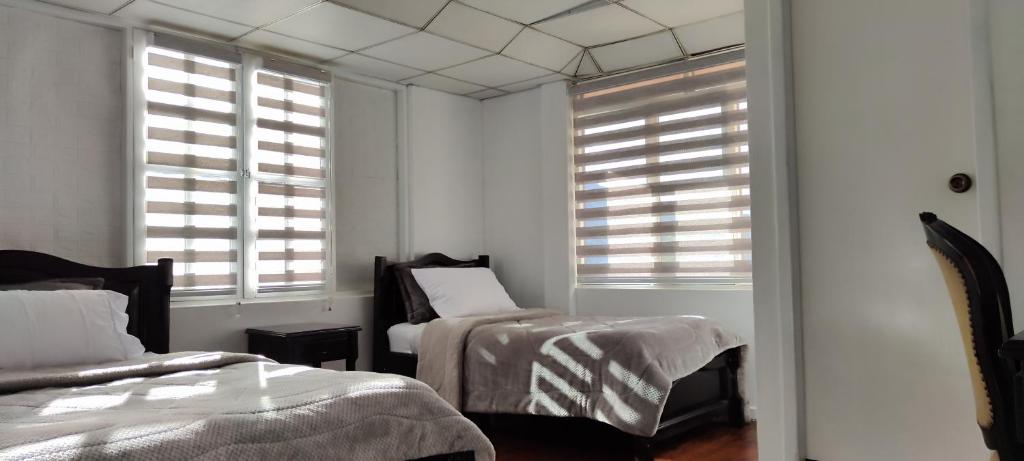 Postel nebo postele na pokoji v ubytování Hotel Muros Quito