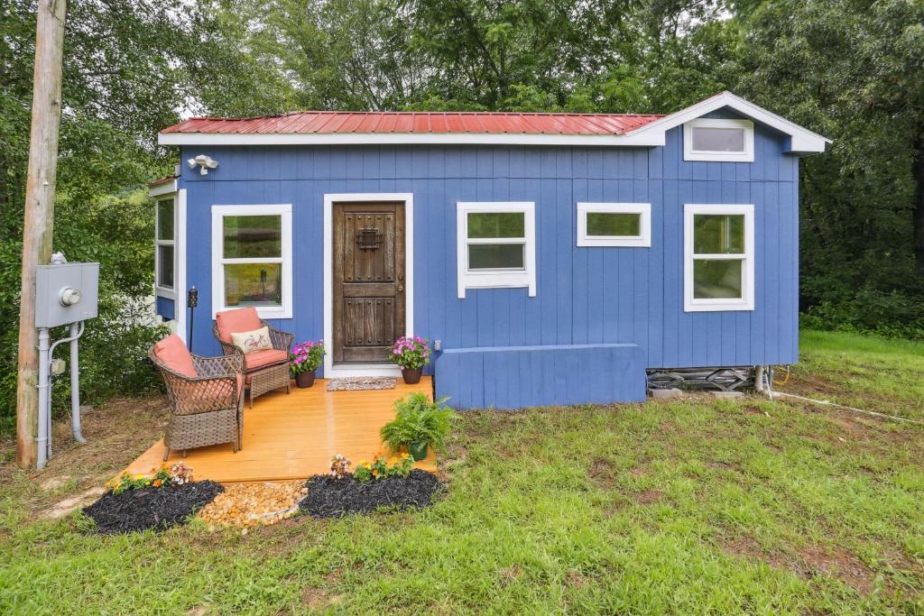 una casita azul en un patio en Pendergrass Tiny Home Cabin on Pond with Fire Pit! en Braselton