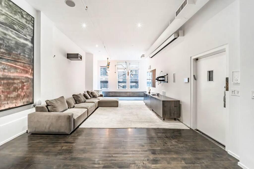 un soggiorno con divano e tavolo di Furnished and Meticulously Renovated 3-bedroom, 2-bathroom Loft a New York
