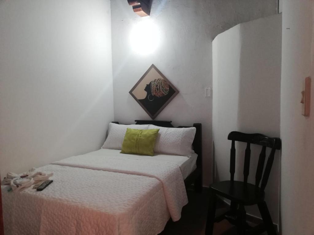 una piccola camera con letto e sedia di Hotel Majestic Mompox a Mompós