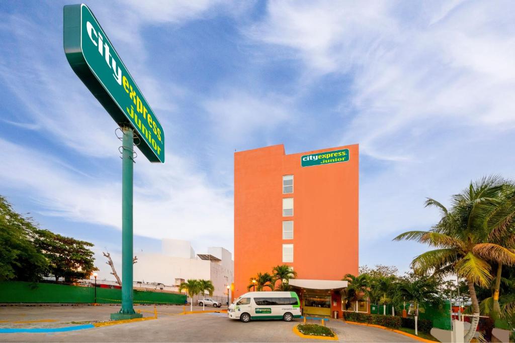 a green street sign in front of a building at City Express Junior by Marriott Ciudad del Carmen in Ciudad del Carmen