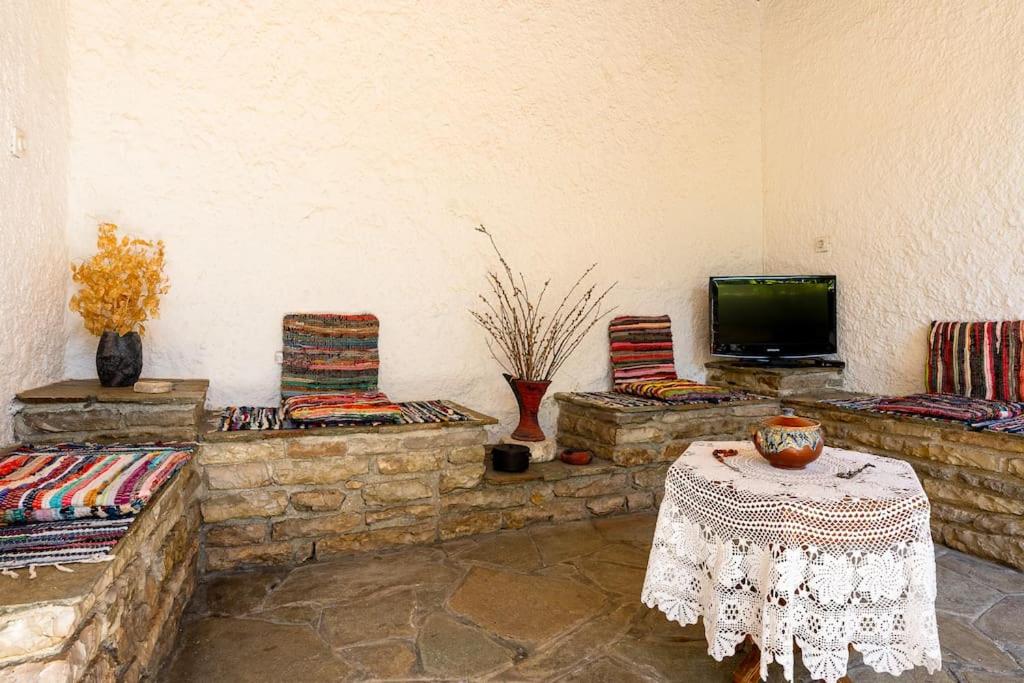a living room with chairs and a table and a tv at Monodendri Vintage House in Monodendri