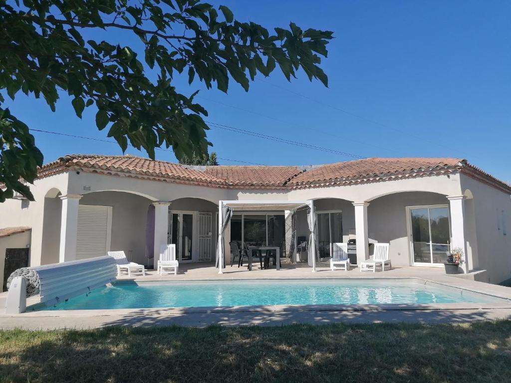 a villa with a swimming pool and a house at Entre Provence et Camargue in Jonquières-et-Saint-Vincent