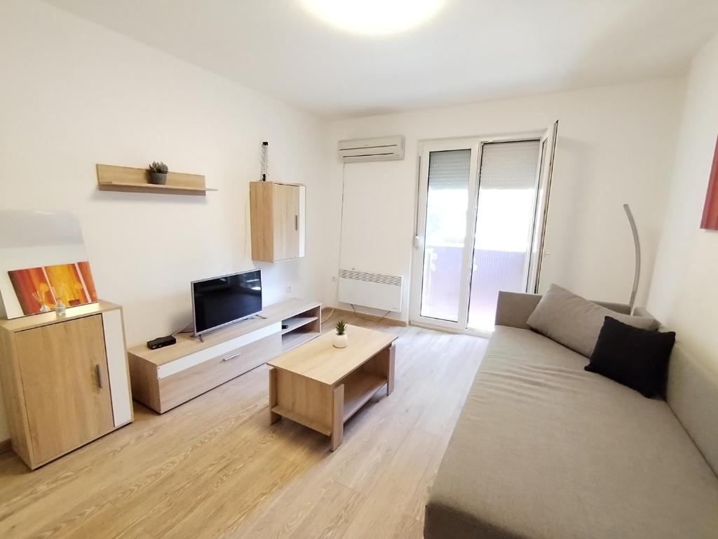 a living room with a couch and a table at Apartman Lola Ruža in Zrenjanin