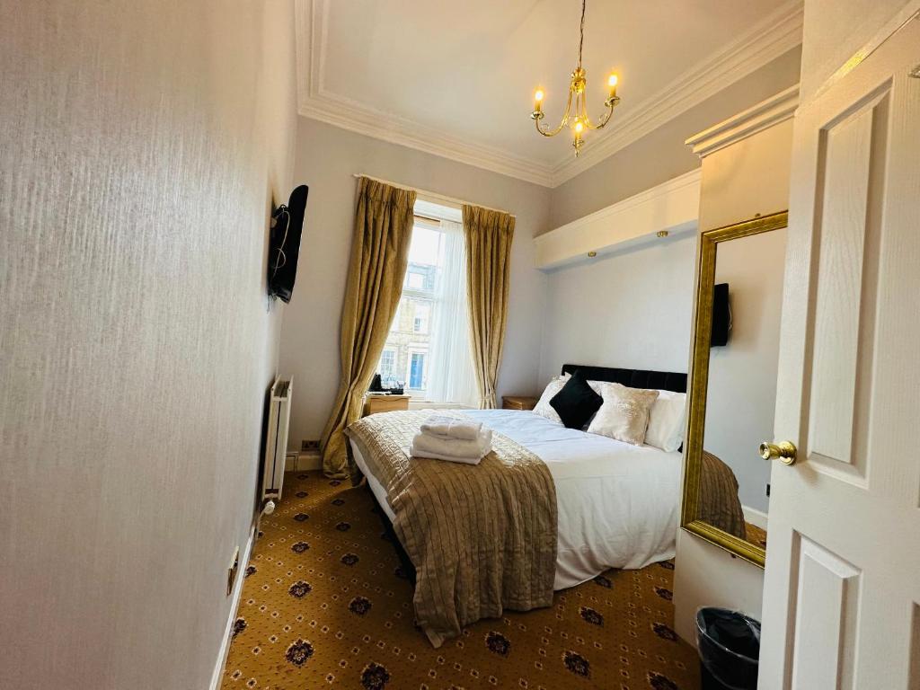 a hotel room with a bed and a mirror at Abbotsford Guest House in Edinburgh