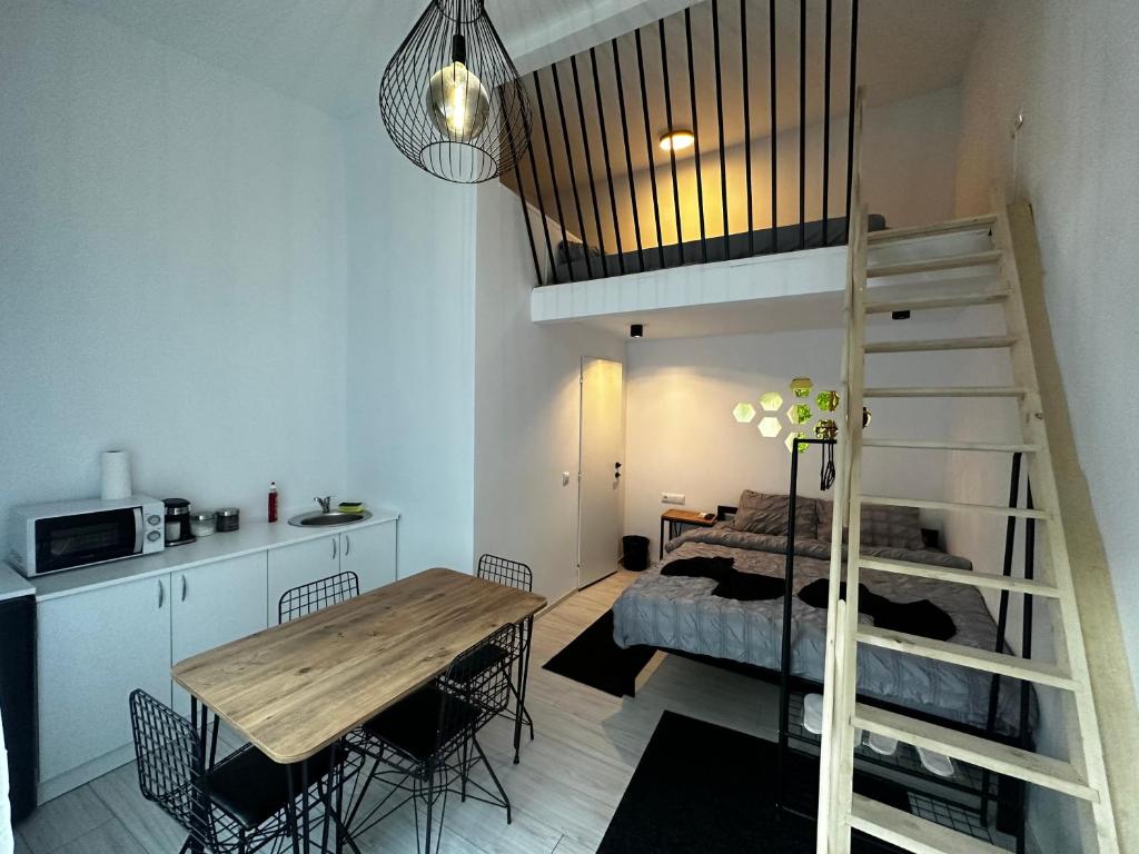 Habitación con cama elevada y mesa con sillas. en Vila Ana 2 Untold en Cluj-Napoca