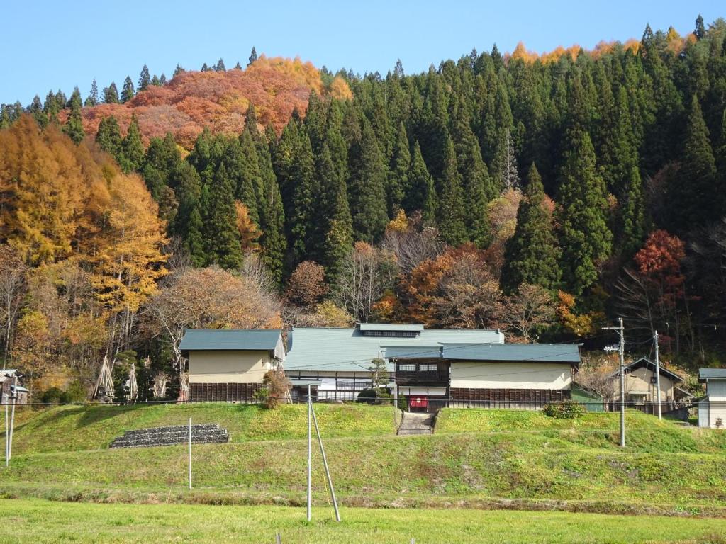 une maison au milieu d'un champ en face d'une montagne dans l'établissement Kominka Resort Nijuyondai - Vacation STAY 24402v, à Nanyo