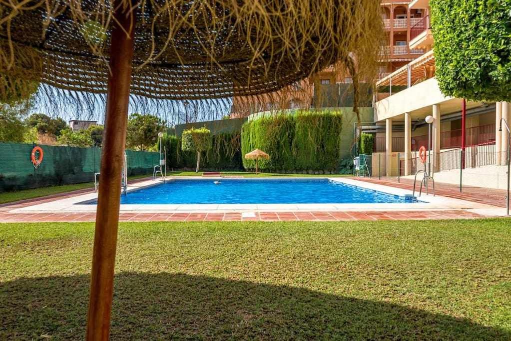 - une piscine dans une cour avec un parasol dans l'établissement ApartRincón Sorolla, à Rincón de la Victoria