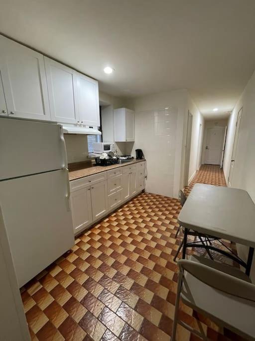 a kitchen with white cabinets and a brown tile floor at 1D CLOSe in New York