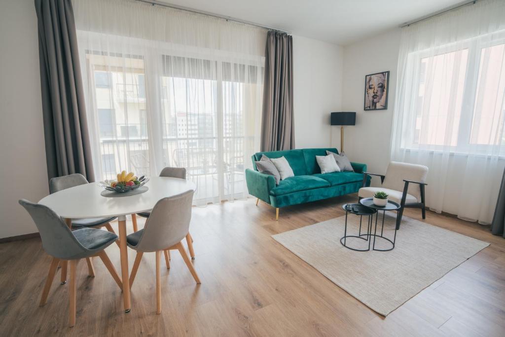 sala de estar con mesa y sofá verde en BP Serviced Apartment en Budapest