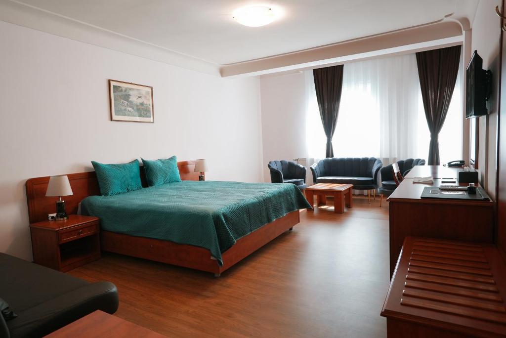 a bedroom with a bed and a living room at Hotel Gold Inn in Peje