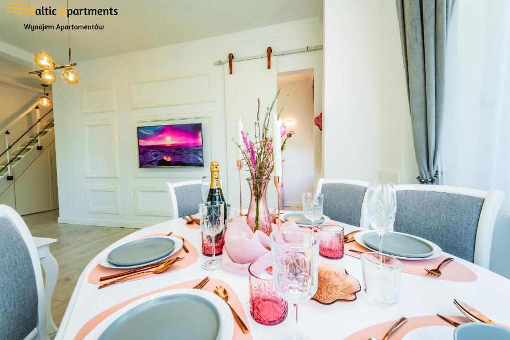 a dining room table with a white tablecloth and blue plates at Baltic Apartments - Willa Carmen DeLuxe in Świnoujście