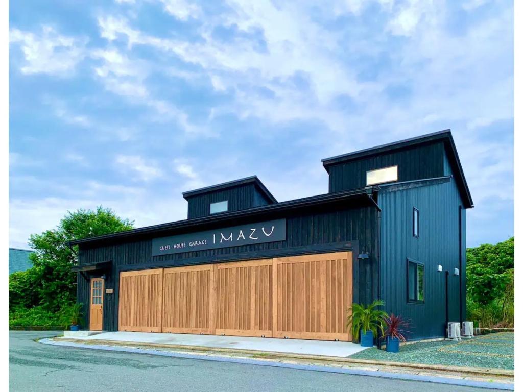 a black and wooden building with a garage at Guest House Garage IMAZU - Vacation STAY 15208 in Takashima