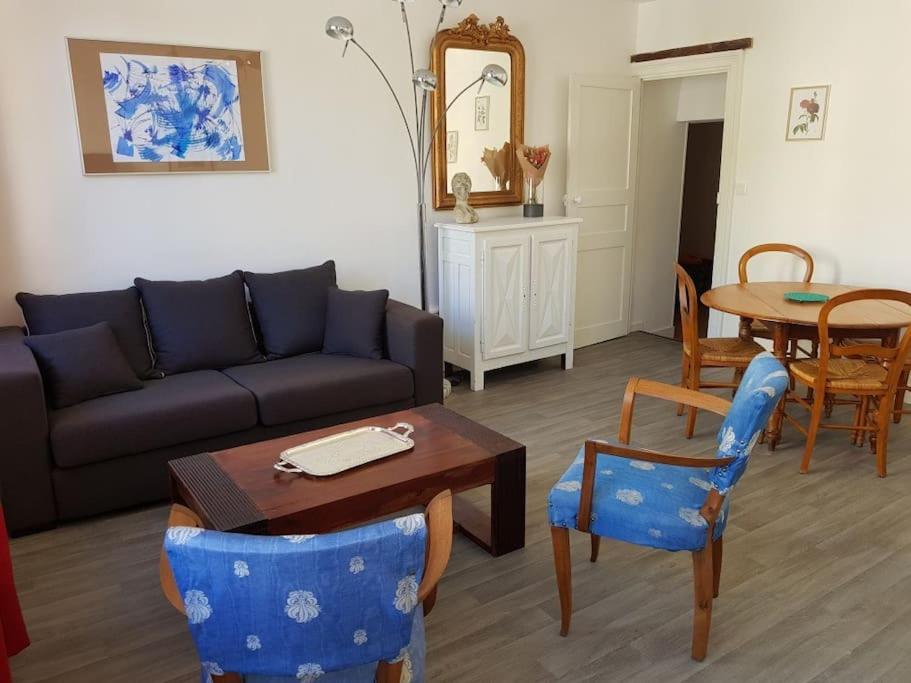 a living room with a couch and a table and chairs at Côté Château in Chinon