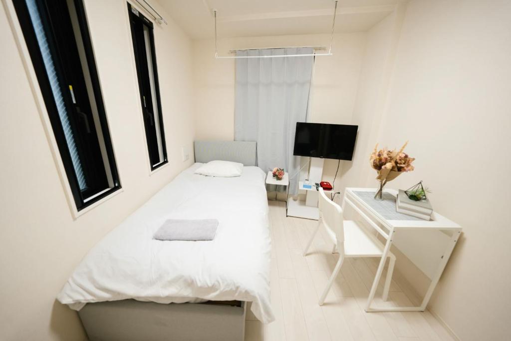 - une petite chambre avec un lit et un bureau dans l'établissement FL Rejidence Shinjuku 2 - Vacation STAY 15187, à Tokyo