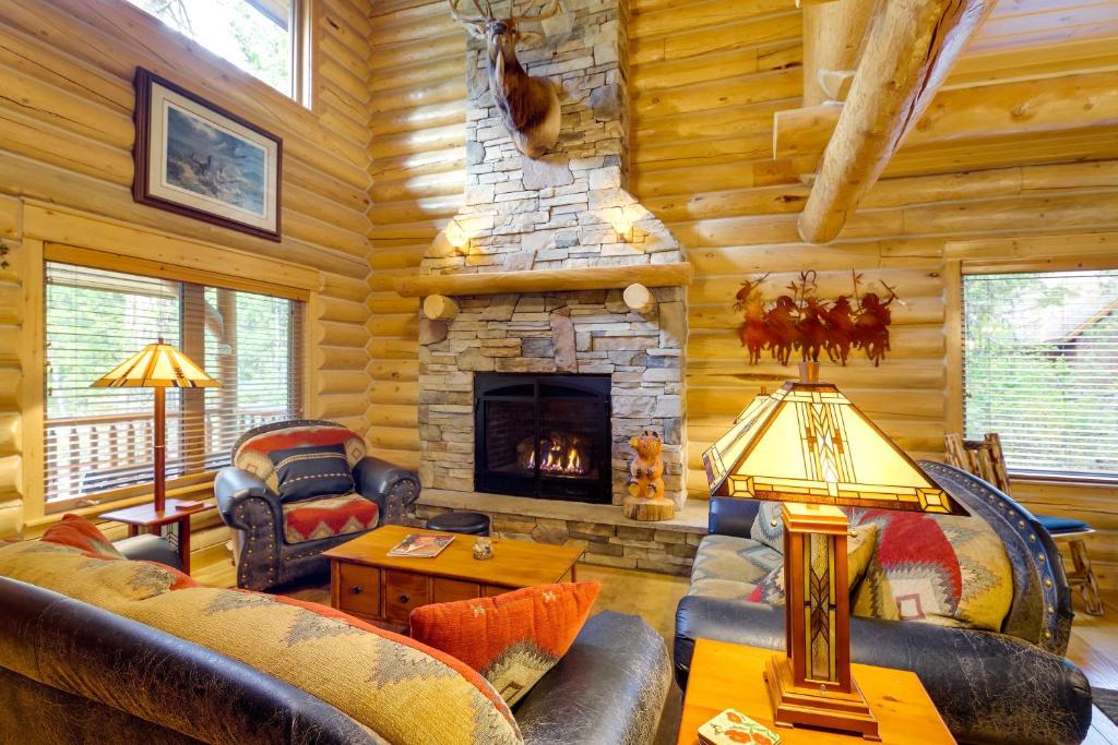 Cabaña de madera con sala de estar con chimenea en Exquisite McCall Log Cabin - Walk to Payette Lake!, en McCall