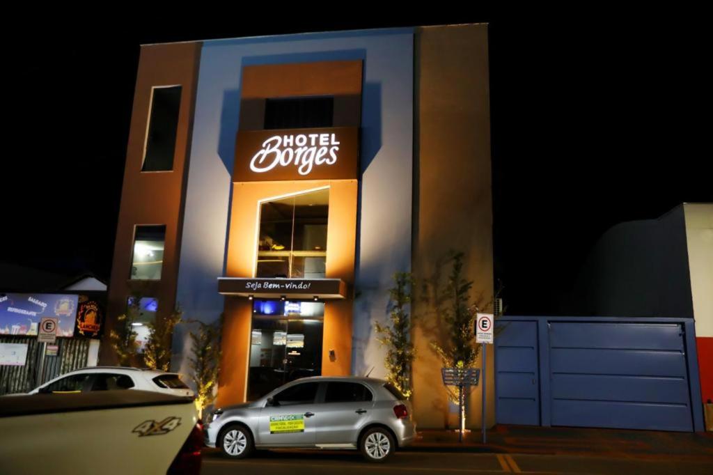 a moteleyes sign on a building with a car parked outside at Hotel Borges in Quirinópolis