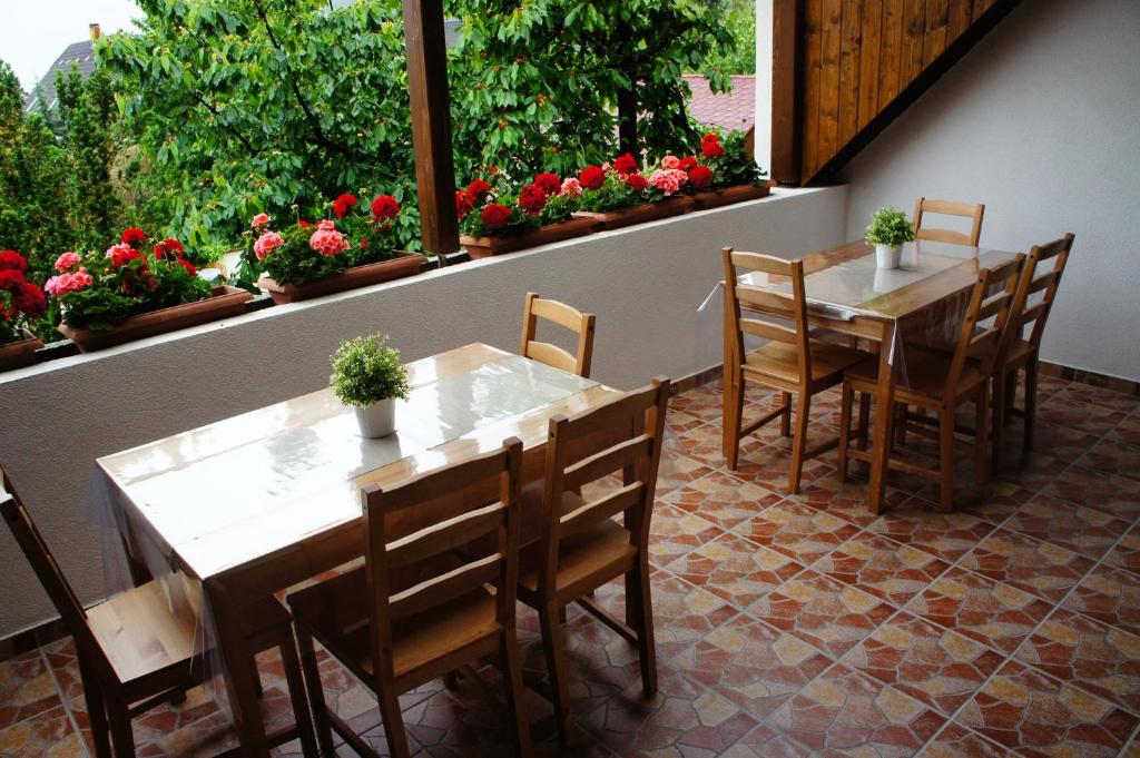 un restaurante con 2 mesas, sillas y flores en Dobosi Pincészet en Szentantalfa