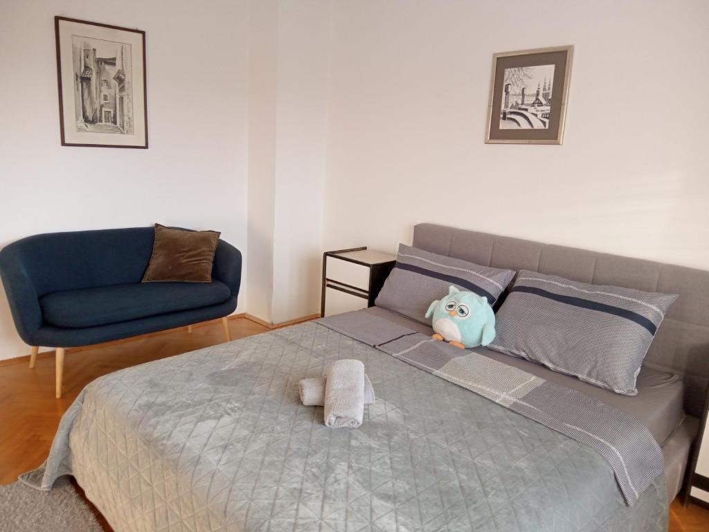 1 dormitorio con 1 cama y 1 silla azul en Owl NEST, Homestay Rooms, en Knin