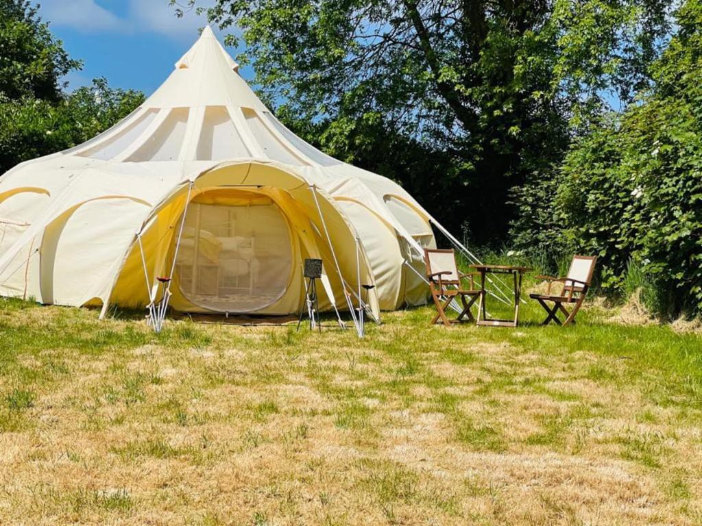 uma grande tenda com duas cadeiras num campo em Tallulah Belle em Abbots Bromley