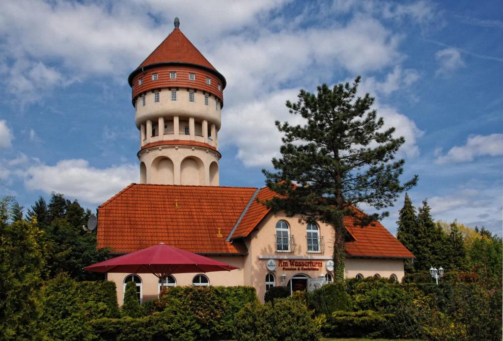 a building with a lighthouse on top of it at Am Wasserturm Pension in Bad Muskau