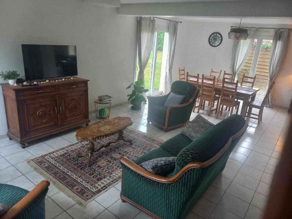 un salon avec un canapé, des chaises et une table dans l'établissement Binic 700m de la plage 4 chambres, jardin, linge, wifi, à Binic