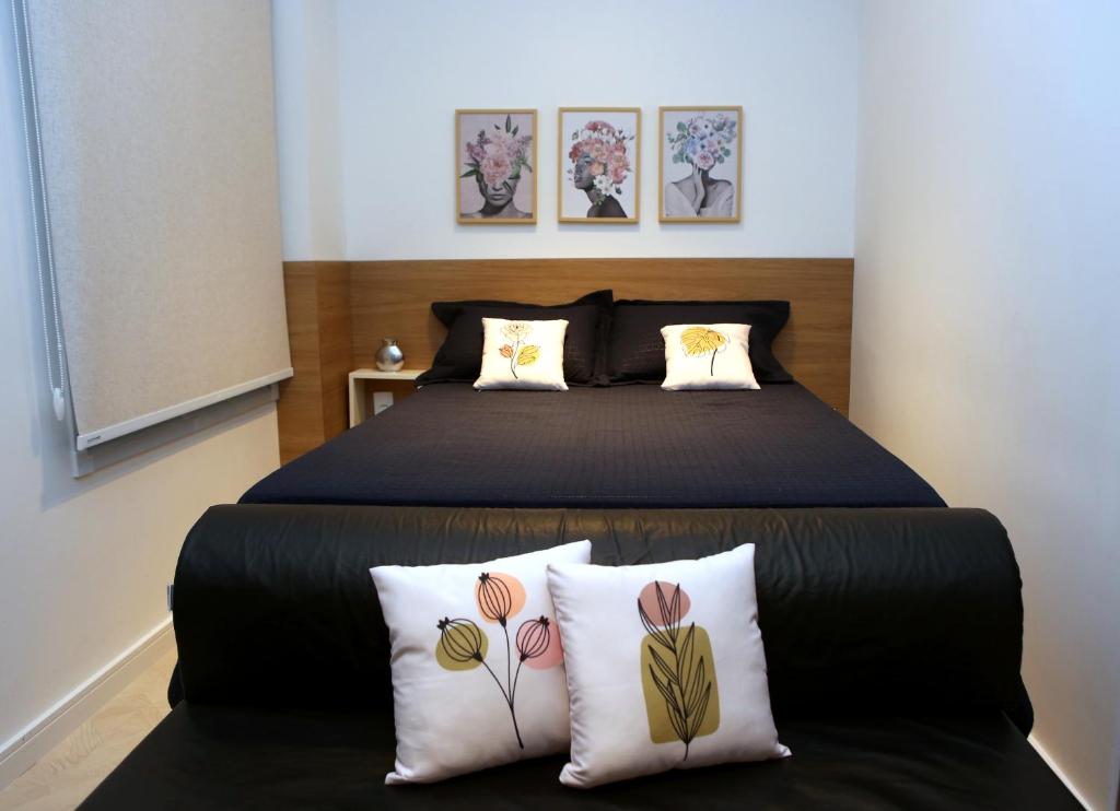 - une chambre avec un grand lit noir et deux oreillers dans l'établissement FLAT Paulista com varanda perto do Metrô, à São Paulo