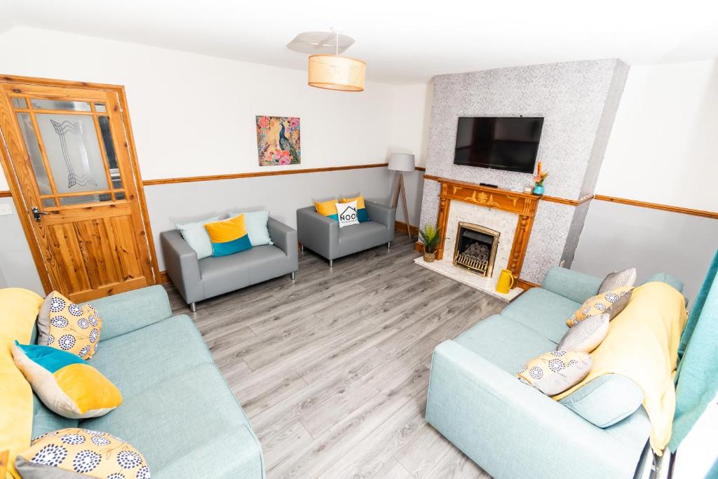 ein Wohnzimmer mit 2 blauen Sofas und einem Kamin in der Unterkunft Greenbourne - 4 bedrooms Sleeps 8 free parking in Gateshead