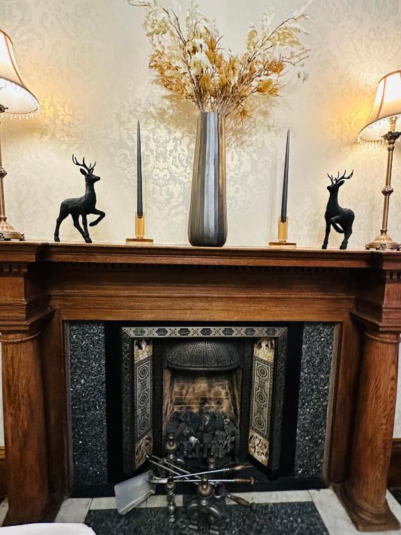 a fireplace with two deer statues on top of it at Abbotsford Guest House in Edinburgh