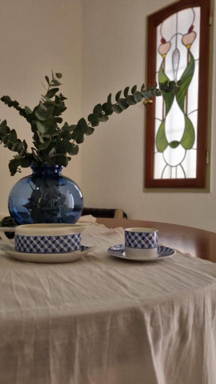 a table with two plates and a vase with a plant at Departamento Aristobulo in La Cieneguita