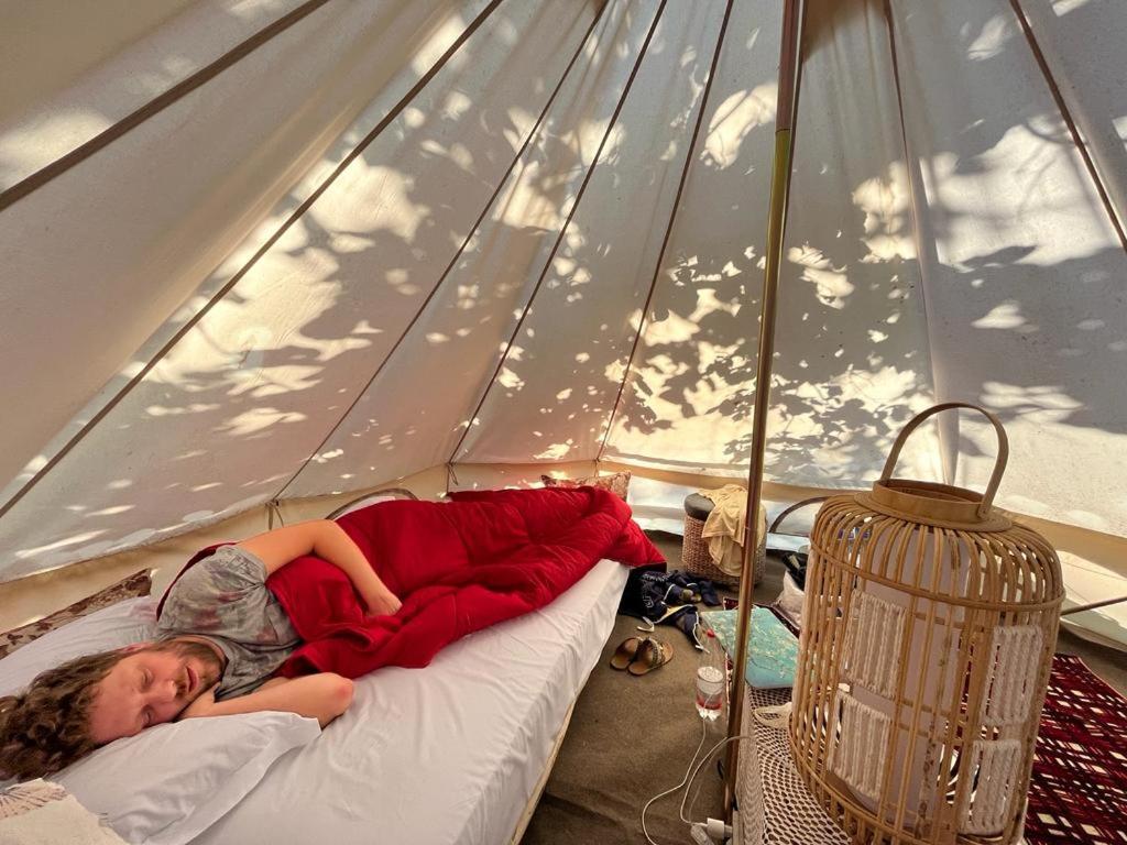 a girl laying on a bed in a tent at Yurta con uso piscina e vista meravigliosa in Dicomano
