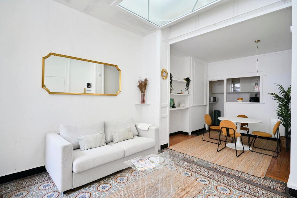 un salon avec un canapé blanc et une table dans l'établissement Appartement cosy au centre de Lille, à Lille